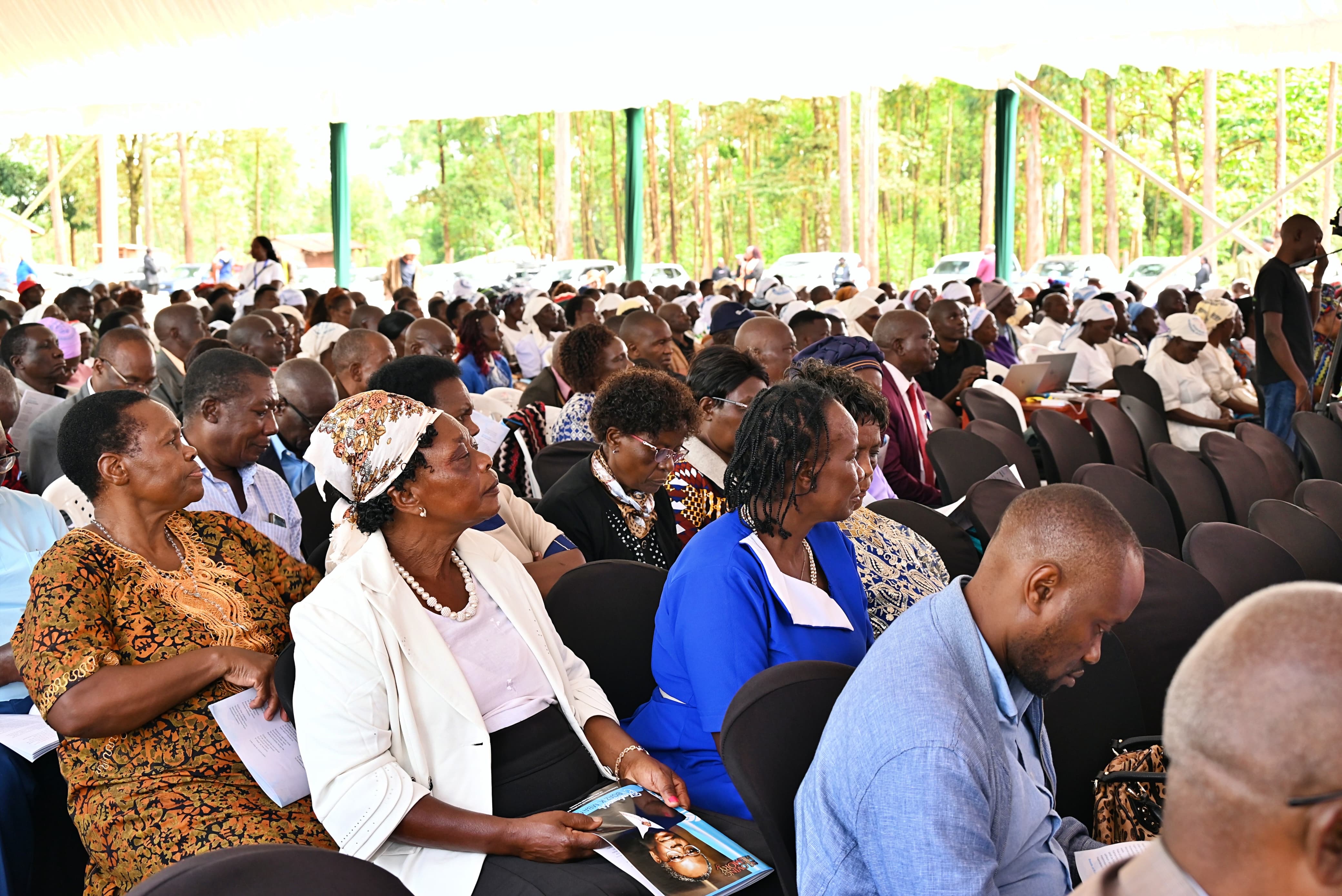 Mourners follow the proceedings with solemn expressions during the funeral service of Ambassador Boaz Mbaya in Vihiga County.